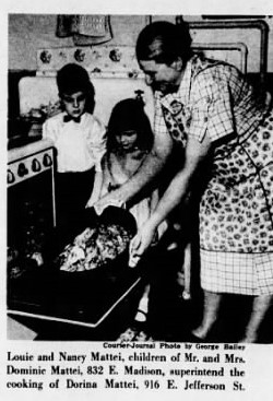 A woman and two children cooking food in an old fashioned kitchen.