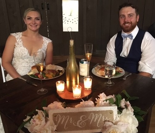 A man and woman sitting at the table with wine.