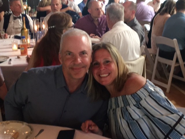 A man and woman smile for the camera at an event.