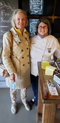 Two women standing next to each other in front of a table.