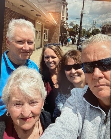 A group of people taking a selfie in front of some buildings.