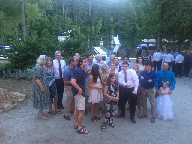 A group of people standing in front of trees.