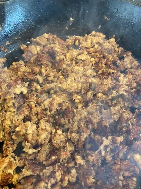 A pan filled with ground meat and other food.