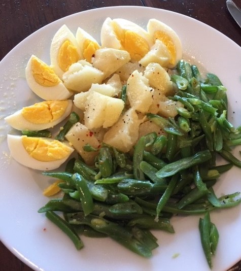 A plate of food with eggs and green beans.