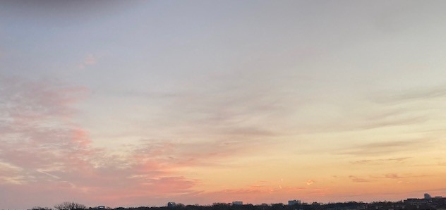 A sky filled with pink and blue clouds at sunset.