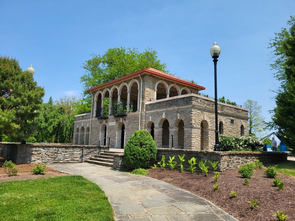 P4 A stone building with a brick walkway and bushes.