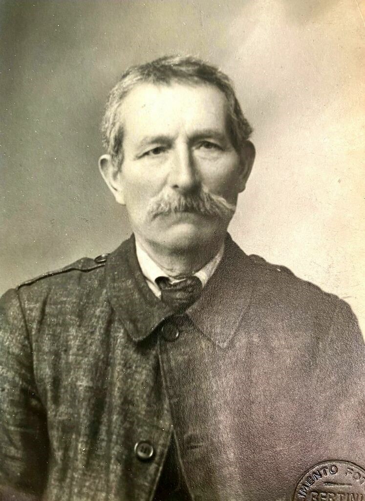 A man with a mustache and beard wearing a suit.