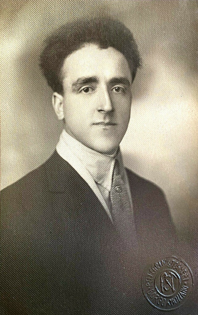 A man in suit and tie with short hair.