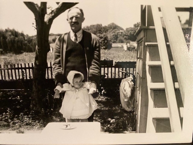 A man and child standing in front of a tree.