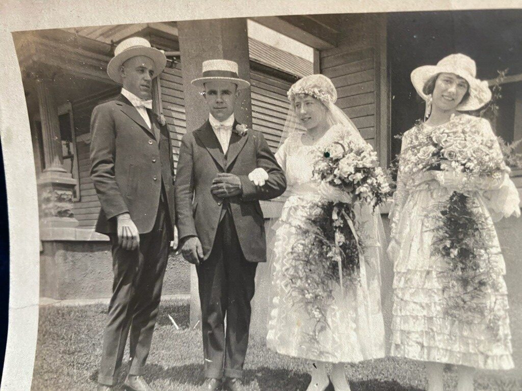 A black and white photo of two men, one in suit and the other in hat.