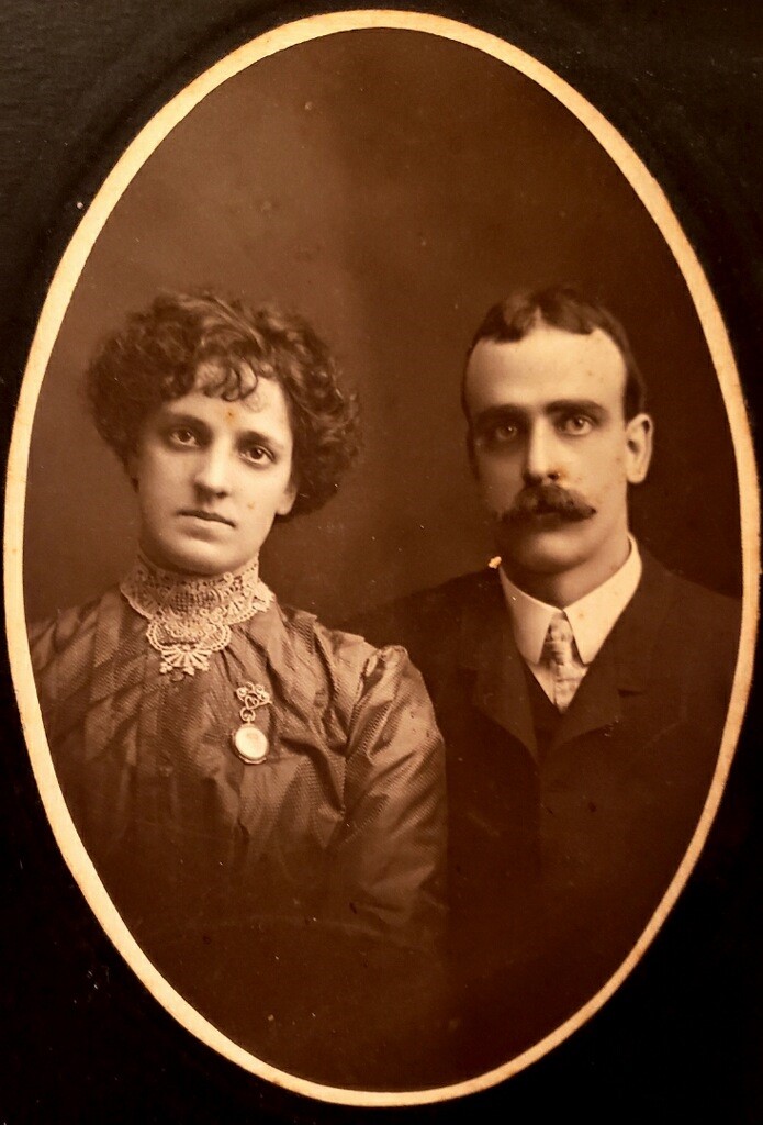 A man and woman standing in an oval photo.