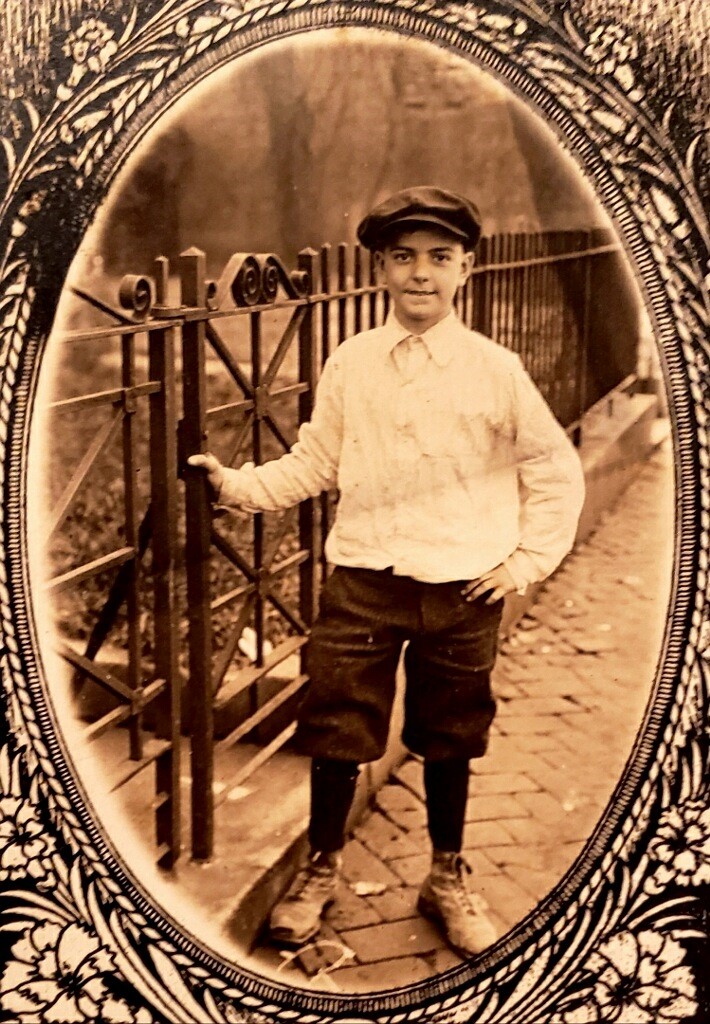 A man standing in front of a fence.