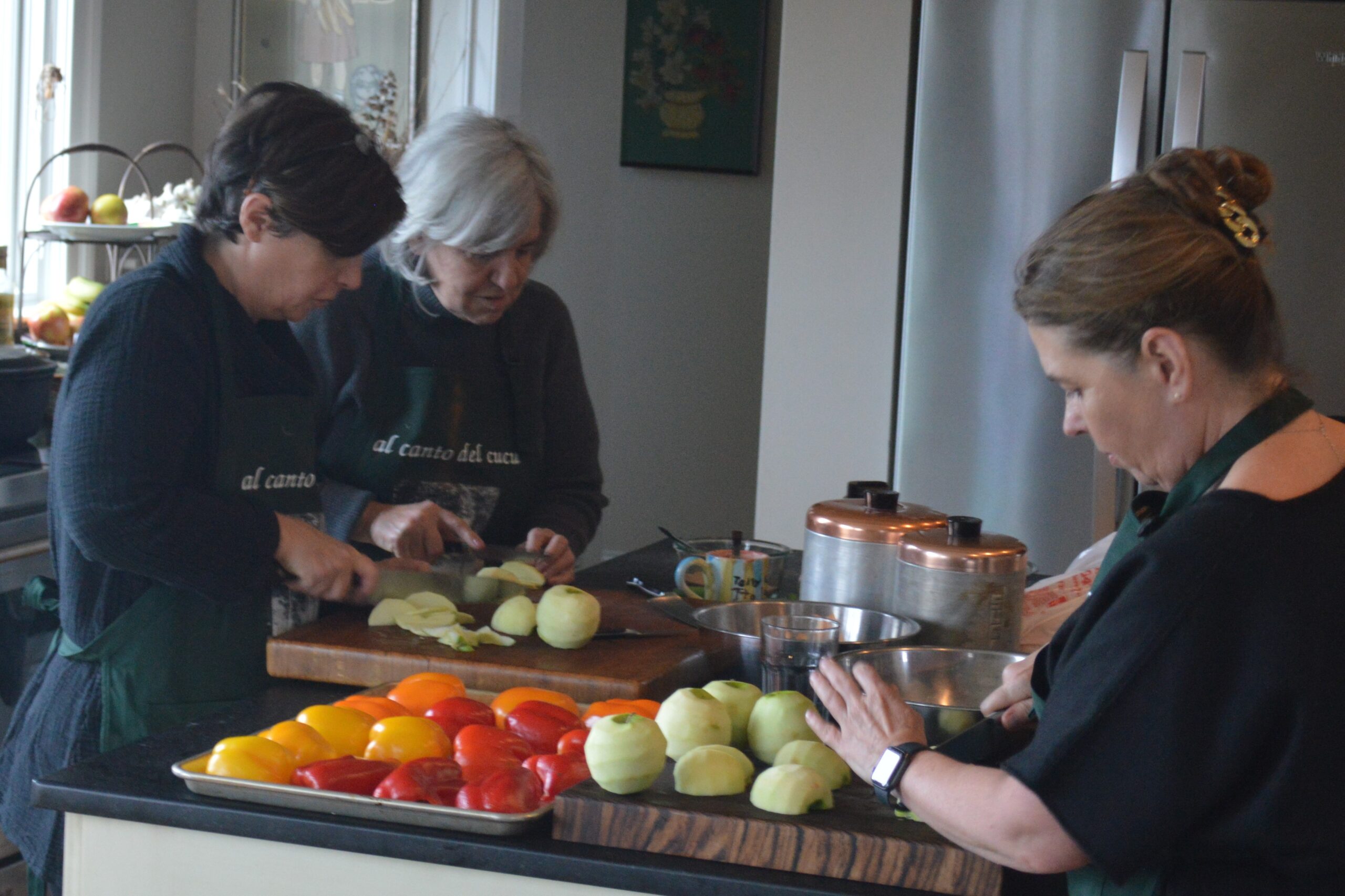 Three women are preparing a meal in the kitchen.