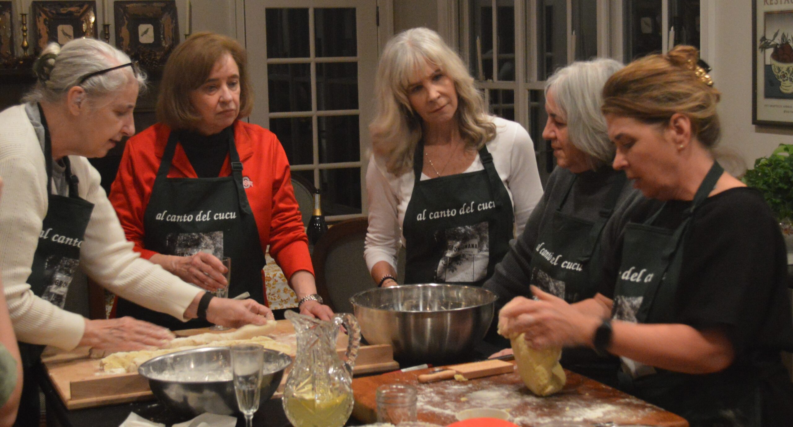 A group of women standing around a table.