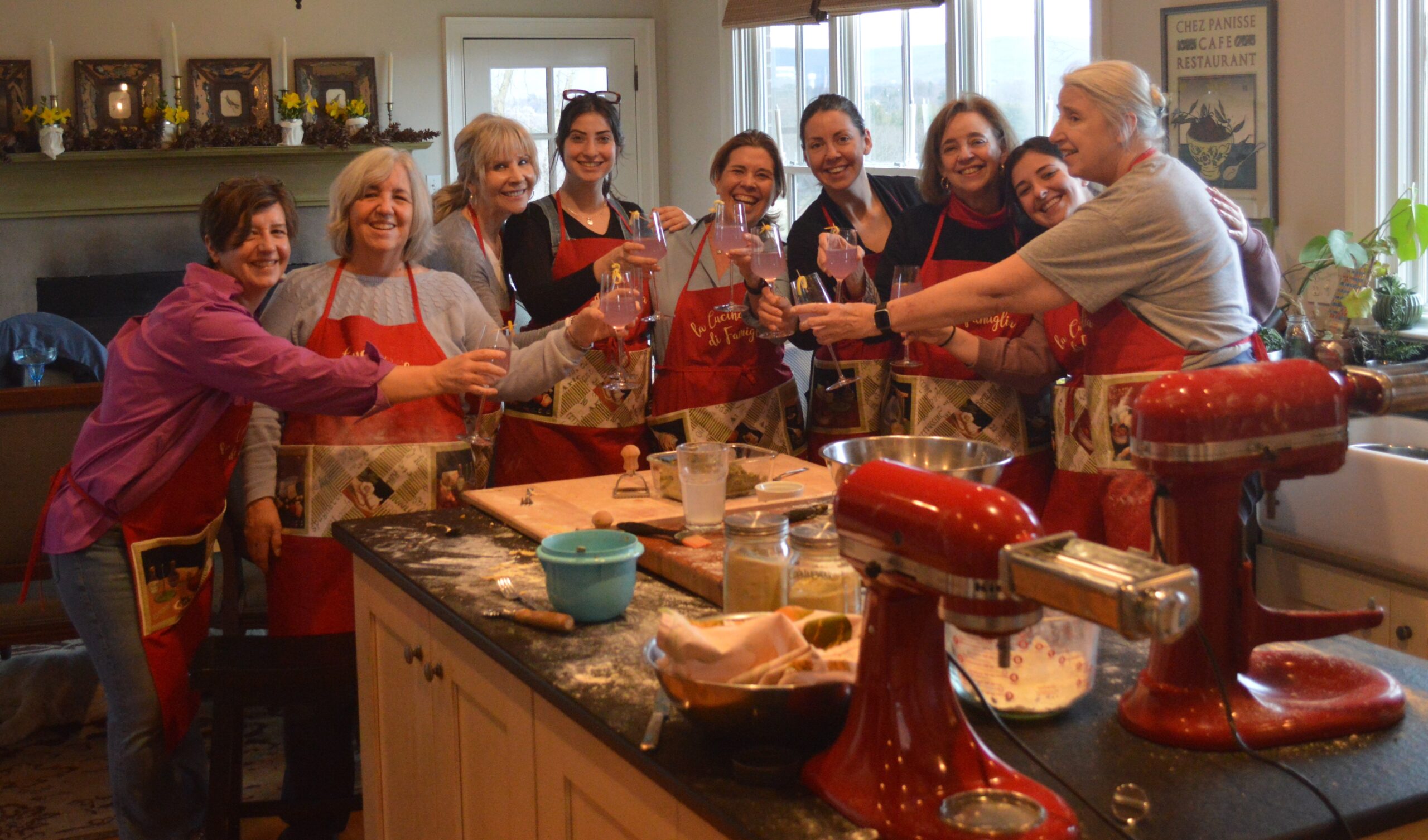 A group of people in aprons standing around a kitchen.