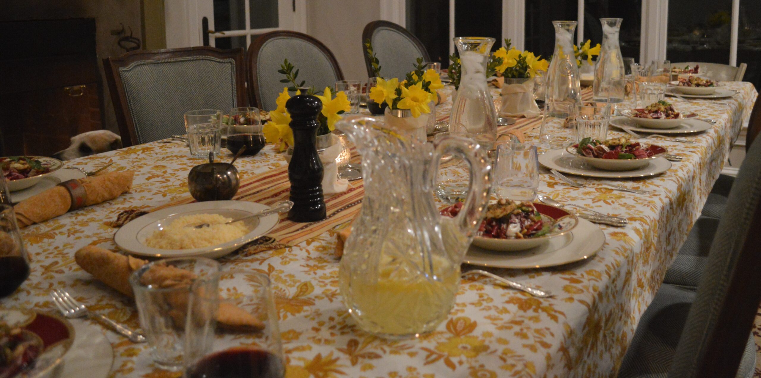 A table set with yellow flowers and wine.