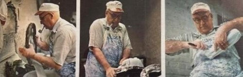 A man in an apron and hat is standing near some food.